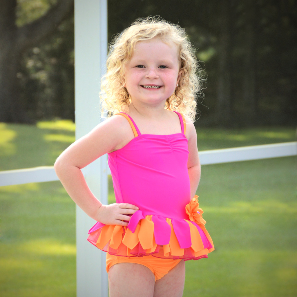 AnnaLane is wearing our Sunburst tankini set, style 8698NFA, available in sizes 3M-6X.