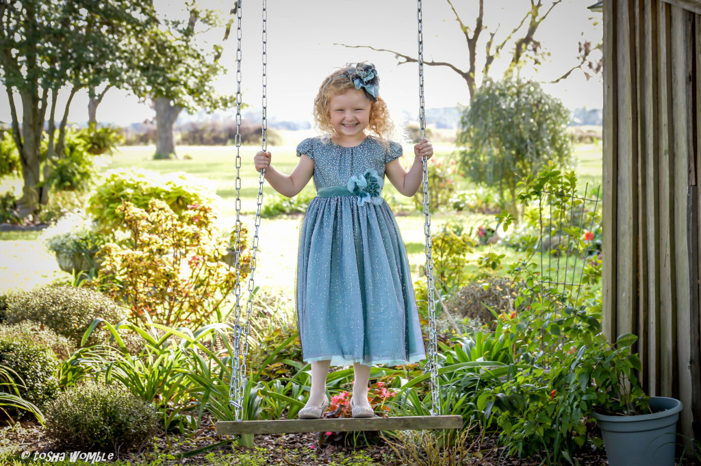 AnnaLane is wearing the Winter Sparkle dress, style 9158TL, available in size 3M-6X.